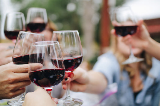 group of people holding a wine glass of red wine